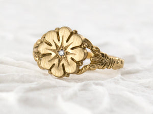 Vintage style flower ring with a diamond center, front view