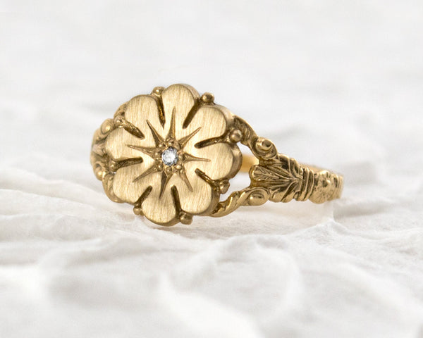 Vintage style flower ring with a diamond center, front view