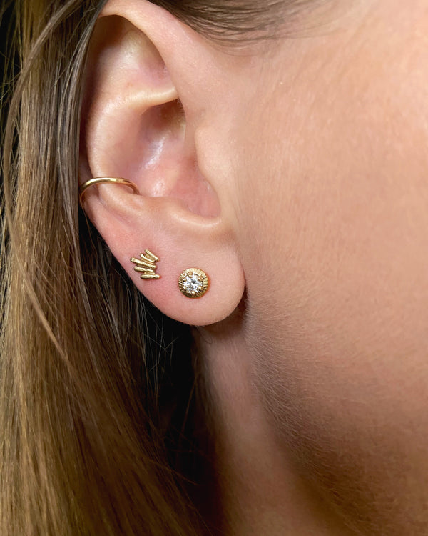 Unique, gold stud earrings modeled