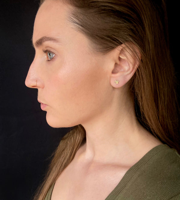 Unique, gold stud earrings modeled