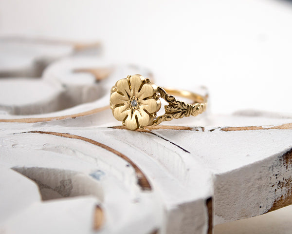 Vintage style flower ring with a diamond center, front view