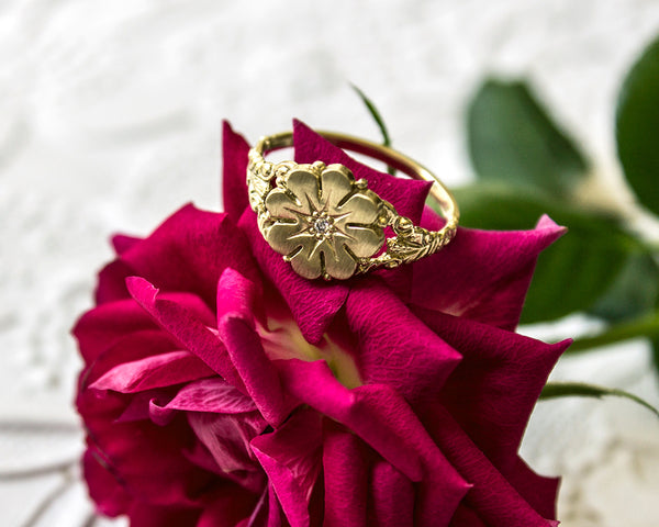 Vintage style flower ring with a diamond center, front view