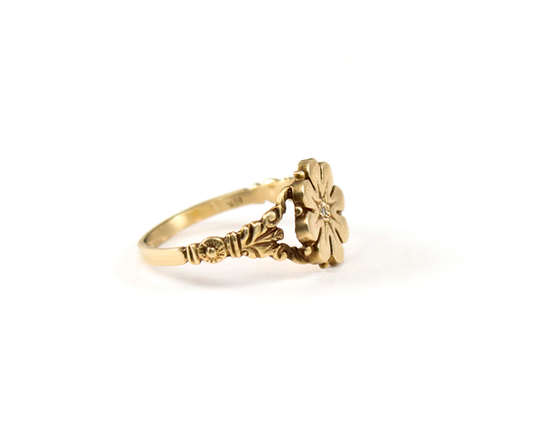 Vintage style flower ring with a diamond center, side shank details