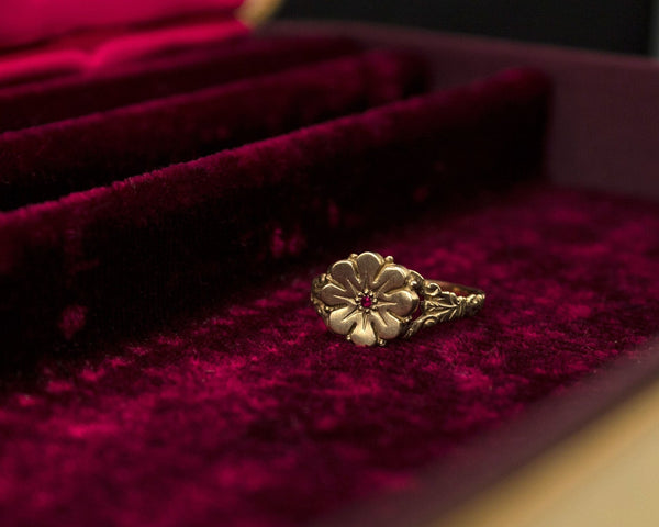 Vintage style flower ring with a ruby center, front view