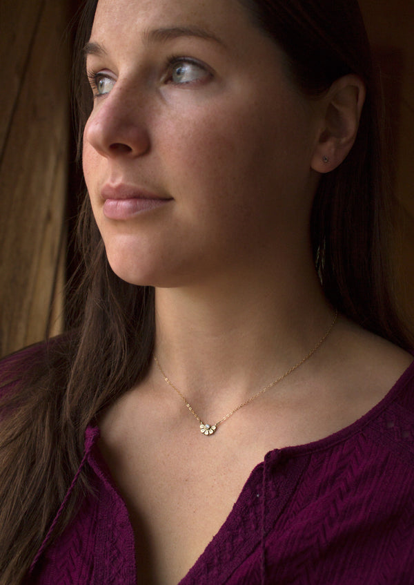 Dainty gold necklace, flower design modeled