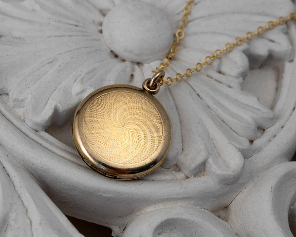Back of Small, round vintage locket with dog