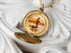 Small, round vintage locket with dog