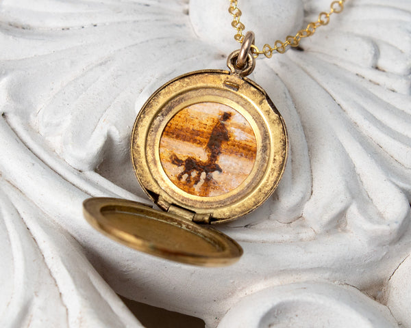 Small, round vintage locket with dog