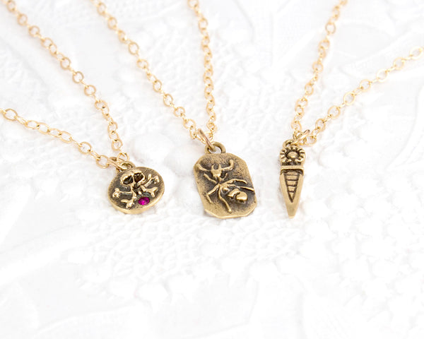 three necklaces: skull and cross bones, ant, and spike
